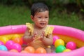 happy infant baby girl playing water with colorful plastic balls in inflatable pool Royalty Free Stock Photo