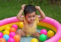 happy infant baby girl playing water with colorful plastic balls in inflatable pool Royalty Free Stock Photo