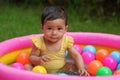 happy infant baby girl playing water with colorful plastic balls in inflatable pool Royalty Free Stock Photo