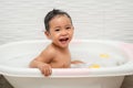 happy infant baby take a bath and playing with foam bubbles in bathtub Royalty Free Stock Photo