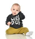 Happy infant child baby boy sitting smiling calling by mobile ce