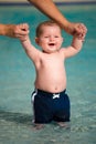 Happy infant playing and wading in shallow pool