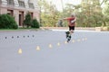 Happy inline skater slaloming between orange chips at skate park Royalty Free Stock Photo