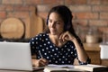 Happy interested young hispanic woman studying distantly.