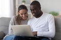 Happy international couple relax at home using laptop Royalty Free Stock Photo