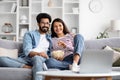 Happy international couple watching movie on laptop at home Royalty Free Stock Photo