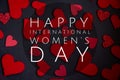 Happy International Women`s Day lettering with white text on black background with red heart