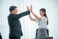 happy interracial businessperson giving high five while working near laptop at workplace, celebrating shared goal achievement,