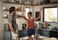 Happy interracial couple dancing, having fun and bonding together in the kitchen at home. Carefree, cheerful and loving Royalty Free Stock Photo