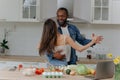 Happy interracial couple dancing in the kitchen. African-American man and woman having fun in the kitchen Royalty Free Stock Photo