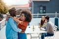Happy interracial couple hugging while spending time together outside at a restaurant with friends. African american man Royalty Free Stock Photo