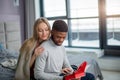 Happy interracial couple spending weekend together at home, relaxing with book