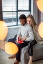 Happy interracial couple spending weekend together at home, relaxing with book