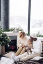 Happy interracial family with baby daughter sits near fireplace and Christmas tree Royalty Free Stock Photo