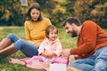 Happy interracial family is enjoying a day in the autumn park. Royalty Free Stock Photo