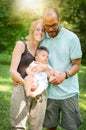 Happy interracial family is enjoying a day in the park with adopted son. Royalty Free Stock Photo