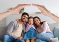 Happy interracial family posing at home under hands roof Royalty Free Stock Photo