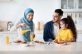 Happy Islamic Family With Little Daughter Having Tasty Lunch In Kitchen Together Royalty Free Stock Photo