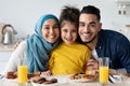 Happy Islamic Parents With Little Daughter Posing In Kitchen, Having Lunch Together Royalty Free Stock Photo