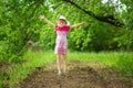 Happy ittle girl in bright dress and funny sunglasses walk in summer garden