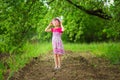 Happy ittle girl in bright dress and funny sunglasses walk in summer garden