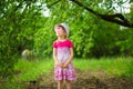 Happy ittle girl in bright dress and funny sunglasses walk in summer garden