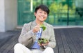 Happy japanese office worker man having lunch sitting outside Royalty Free Stock Photo