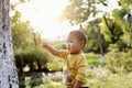 Happy joyful Asia Chinese little boy toddler child enjoy Spring have fun outside embrace nature outdoor carefree childhood flower Royalty Free Stock Photo