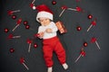 Happy joyful baby boy in Santa Claus hat smiling among Christmas candy canes Royalty Free Stock Photo