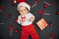 Happy joyful baby boy in Santa Claus hat smiling among Christmas candy canes Royalty Free Stock Photo