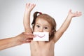 Happy joyful baby girl hiding her face by hand with smile drawn Royalty Free Stock Photo