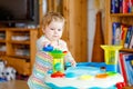 Happy joyful baby girl playing with different colorful toys at home. Adorable healthy toddler child having fun with Royalty Free Stock Photo