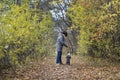 A happy and joyful boy walks with his buddy, a Boston terrier puppy, in a beautiful golden autumn forest. Royalty Free Stock Photo