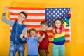 Happy and joyful children flying the American flag, the concept of protection and patronage of the USA