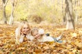 Happy joyful family portrait, blonde mother and blonde daughter have a rest laying outdoor in autumn park Royalty Free Stock Photo