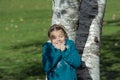 Happy joyful girl with funny reaction covered in shadows and sun rays, hiding behind the birch trees in autumn park on sunny day Royalty Free Stock Photo