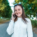 Happy joyful girl teenager 12-15 years old, autumn day, portrait on street, making phone call, summer park. Listens Royalty Free Stock Photo