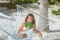 Happy joyful little girl sitting on hammock in tropical garden Royalty Free Stock Photo