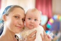 Happy and joyful mother holds the baby in her arms, smiles and looks into the camera Royalty Free Stock Photo