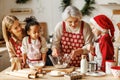 Happy multiethnic family, grandmother, mother and kids cooking together on Christmas day in kitchen Royalty Free Stock Photo