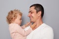 Happy joyful people young man holding little toddler girl isolated on gray background looking at each other with love nad gentle Royalty Free Stock Photo