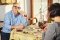 Happy joyful senior couple playing cards and enjoying a snacks. Royalty Free Stock Photo