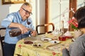 Happy joyful senior couple playing cards and enjoying a snacks. Royalty Free Stock Photo