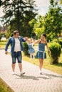 Happy joyful young family father, mother and little daughter having fun outdoors, playing together in summer park Royalty Free Stock Photo