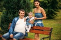 Happy joyful young family father, mother and little daughter having fun outdoors, playing together in summer park Royalty Free Stock Photo