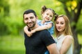 Happy joyful young family father, mother and little daughter having fun outdoors, playing together in summer park, countryside. Royalty Free Stock Photo