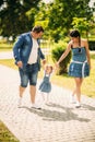 Happy joyful young family father, mother and little daughter having fun outdoors, playing together in summer park Royalty Free Stock Photo