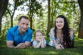 Happy joyful young family father, mother and little daughter having fun outdoors, playing together in summer park. Mom Royalty Free Stock Photo