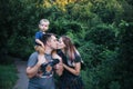 Happy young family father, mother and little son hugging and kissing outdoors, playing together in summer park Royalty Free Stock Photo