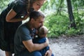 Happy joyful young family father, mother and little son hugging and kissing outdoors, playing together in summer park Royalty Free Stock Photo